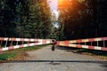 Old gate blocks the road leading to the forest. Protected area, entrance is prohibited, passage is closed. Red-and-white barrier