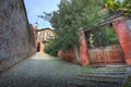 Old gate and narrow paved street in Saluzzo.