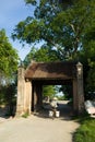 Old gate with woman cycling at Duong Lam old village, Hanoi, Vietnam Royalty Free Stock Photo