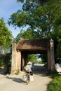 Old gate with woman cycling at Duong Lam old village, Hanoi, Vietnam Royalty Free Stock Photo