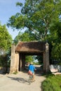 Old gate with woman cycling at Duong Lam old village, Hanoi, Vietnam Royalty Free Stock Photo