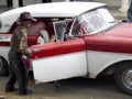 Old gaucho opening a door of a vintage car.