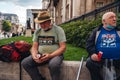 Old Gentlemen sitting at Trafalgar square drinking beer on hot summer da