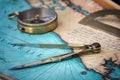An old geographic map with navigational tools: compass, divider, ruler, protractor. View of the workplace of ship`s captain.