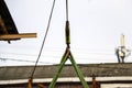 Old girder crane with large iron hook lifts heavy load on slings