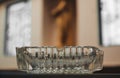 Old glass ashtray on the table on blur wall background, Vintage, dark, copy space