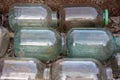 Old glass cylinders of three liters stacked in rows