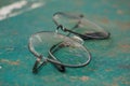 Old glasses and damaged lenses are placed on the green table tennis table.