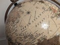 an old globe has an intricate metal frame and map on it Royalty Free Stock Photo