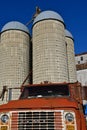 Old GMC truck parked in front of stave silos