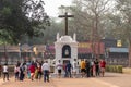 Crowd of Indian tourists around the crucifix at the entrance to the ancient Portuguese era Basilica