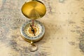 The old gold compass with cover on vintage map, macro background Royalty Free Stock Photo