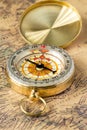 The old gold compass with cover on vintage map, macro background Royalty Free Stock Photo