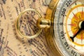 The old gold compass with cover on vintage map, macro background Royalty Free Stock Photo