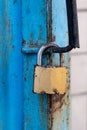 Old gold padlock covered with rust on a blue door Royalty Free Stock Photo