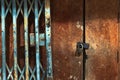 Old gold steel lock and damaged and rusted steel door on wooden door. Locked on wooden door with old steel metal shutter and Royalty Free Stock Photo