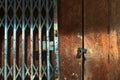 Old gold steel lock and damaged and rusted steel door on wooden door. Locked on wooden door with old steel metal shutter and Royalty Free Stock Photo