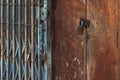 Old gold steel lock and damaged and rusted steel door on wooden door. Locked on wooden door with old steel metal shutter and Royalty Free Stock Photo