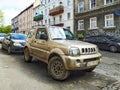 Old golden grey dusty rusty small offroad car Suzuki Jimny 4x4 parked