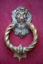 Old golden iron lion head door knocker on a wooden pink door. Mdina, Malta Royalty Free Stock Photo