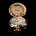 Old golden pocket watch on a black reflective surface Royalty Free Stock Photo