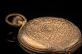 Old golden pocket watch on a black reflective surface Royalty Free Stock Photo