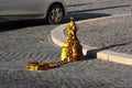 Old golden post with metal chain and ring. Pedestrian area at city street with gold metal pole. The old cast iron street pole on Royalty Free Stock Photo