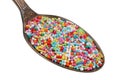 In the old golden spoon there is a small pile of food - a multi-colored candy for cake decorating isolated macro Royalty Free Stock Photo
