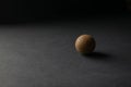 Old golf ball on the black surface with black background with light and shadows. Copy space with used selective focus Royalty Free Stock Photo