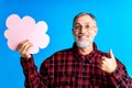 old good looking man making important life choices with paper card in cloud shade blue backgrond studio Royalty Free Stock Photo