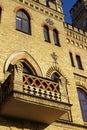 Old gothic castle balcony on yellow brick wall with arched windows Royalty Free Stock Photo