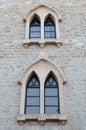 Old Gothic Windows in the shape of a peak in a stone building. Royalty Free Stock Photo