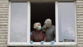 Old grandparents stay at window isolated at home on quarantine. Coronavirus