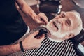 Old grandfather smiles as he gets his hair cut.