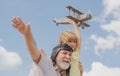 Old grandfather and young child grandson having fun with toy plane on sky. Child dreams of flying, happy childhood with