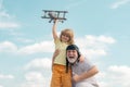 Old grandfather and young child grandson playing with plane together on blue sky. Cute boy with granddad playing outdoor