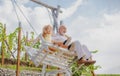 Old grandfather and young child grandson swinging in garden outdoors. Grand dad and grandson sitting on swing in park Royalty Free Stock Photo