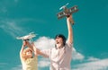 Old grandfather and young child grandson with toy jetpack plane and quadcopter drone against sky. Child pilot aviator