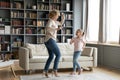 Old grandmother dancing to music with energetic granddaughter. Royalty Free Stock Photo