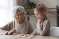 Old grandmother playing draughts with adorable little child girl. Royalty Free Stock Photo