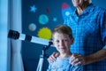 Confident child with grandfather and telescope in bedroom Royalty Free Stock Photo