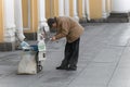 Old grandpa is standing on the sidewalk selling Newspapers. Unemployed people don`t want to be quarantined