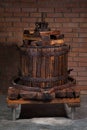 Old grape press machine wooden barrel on a brick wall background. Homemade ecological wine production on the farm Royalty Free Stock Photo