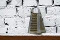 Old grater of Soviet times stands near the whitewashed brick wall Royalty Free Stock Photo