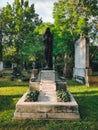 Old grave with a monument to a famous person in the cemetery. Architectural stone statue,old historic grave and funeral monument.