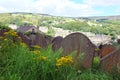 Gravestones overgrown with weeds overlooking the town of hebden bridge at the disused cross lanes former methodist burial ground