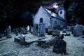 Old graveyard with ancient tombstones grave stone and old church front of full moon black raven dark night spooky horror