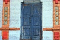 Old gray blue closed door on a colored brick wall Royalty Free Stock Photo