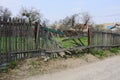 Gray broken wooden plank fence in green grass on a rural street Royalty Free Stock Photo