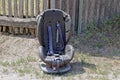 The old gray car seat is on the ground near the fence Royalty Free Stock Photo